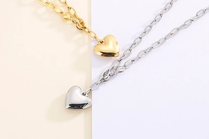 Detailed view of gold and silver chunky chain necklaces with 3D heart pendants