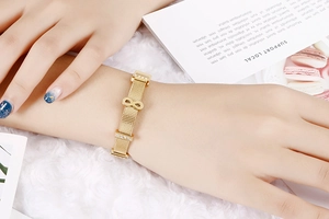 Detailed macro view of 18k gold plated infinity symbol with micro zircons on mesh band