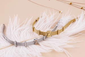 Détail de bracelets en maille avec nœuds en cristal et breloques cœur en or et argent