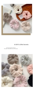 Close-up of soft plush scrunchies in pastel colors on a rustic wooden tray