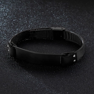 Macro detail of men's matte black stainless steel mesh bracelet on dark textured background
