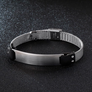 Close-up of men's stainless steel mesh bracelet with black leather and engraved metal plate