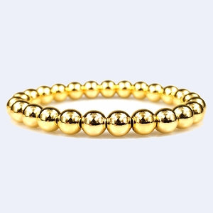 Detailed view of high-polished 18K gold-plated copper beads on a stretch bracelet