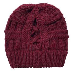Close-up of burgundy knit beanie with high ponytail hole and cross strap detail