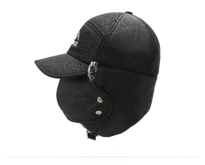 Detail view of winter trapper hat showing black textured fabric and side metal buckle