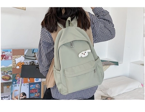 Zaino verde minimalista impermeabile in nylon per studenti in un ambiente di vita reale