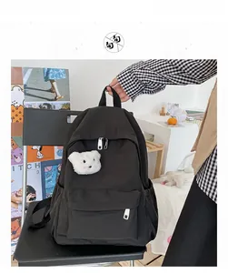 Dettaglio dello zaino in nylon nero impermeabile con un simpatico ciondolo a forma di orso