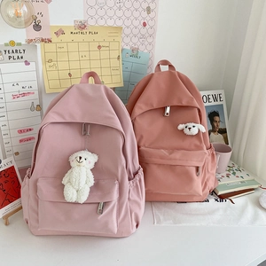 Minimalist waterproof nylon backpack for women in pink and red with plush bear charms