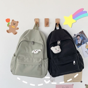 Dettaglio dello zaino in nylon impermeabile con ciondolo animale in nero e verde matcha