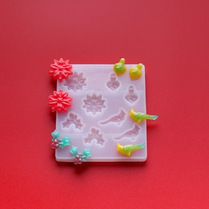 Detail view of a white silicone DIY mold with Christmas flower and bird shapes