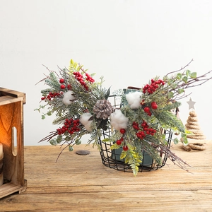 Christmas pine needle wreath with red berries, cotton and pine cones in black wire basket