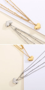 Detail von doppellagigen Perlenketten mit goldenen und silbernen Herzanhängern aus Metall