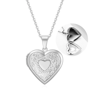 Macro detail of openable heart locket necklace with floral relief and internal photo slot