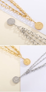 Detail of layered gold and silver coin necklaces featuring Queen Elizabeth II pendants
