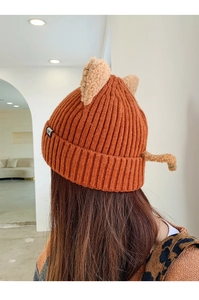 Close-up of orange knitted cat ear beanie showing the cute animal design and CAT label