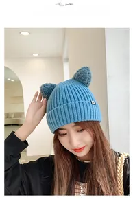 Close-up of blue knitted beanie with cute plush cat ears and soft ribbed texture detail