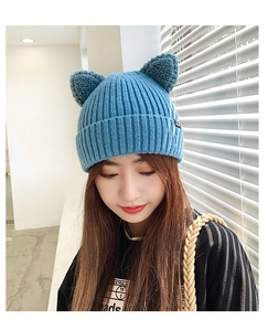 Detailed texture of blue knit beanie featuring cute cat ears and small side label