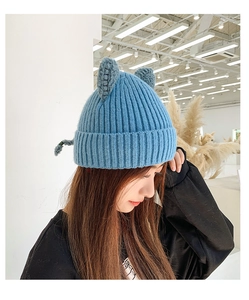 Close-up of blue knitted winter hat featuring cute cat ears and soft texture details