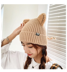 Detailed shot of khaki knitted beanie featuring cute cat ears and a CAT brand label