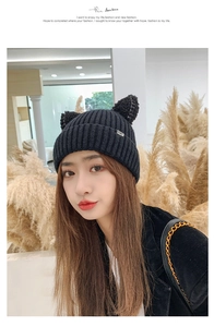 Detailed view of black ribbed knit beanie featuring cat ears and CAT woven label