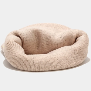 Close-up of beige knitted beanie showing soft fabric texture and fine crochet craftsmanship