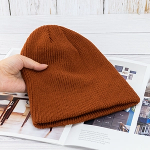 Detailaufnahme der karamellfarbenen Strickmütze mit feiner Textur auf einem Magazin