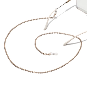 Close-up of golden beaded eyewear chain with non-slip rubber ends on white background