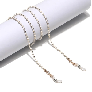 White and gold beaded sunglasses chain with metal hooks wrapped on a display stand