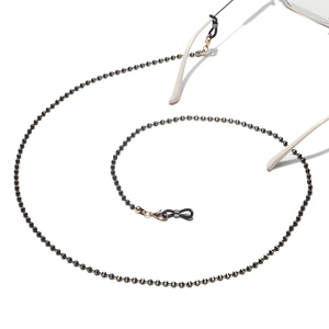 Detail of beaded eyewear chain with black and gold metal beads on a clean white background