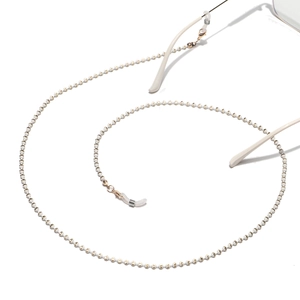 Macro detail of cream and gold beaded eyeglass chain with anti-slip silicone loops