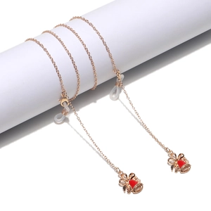 Rose gold metal eyewear chain with red bell pendants and anti-slip silicone loops