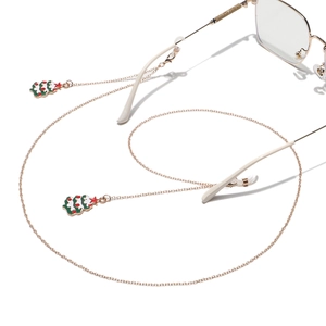 Detail of gold metal eyewear chain featuring festive Christmas tree charms and non-slip loops