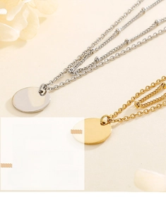 Macro shot of polished gold and silver circular pendants on delicate steel chains