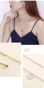 Detail of layered thin bead chains with a round pendant in silver and gold finishes