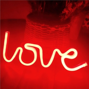 Macro view of glowing red LED Love neon sign light for romantic proposal decor