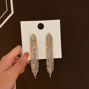 Detail of gold geometric earrings with long sparkling rhinestone tassels on S925 silver studs