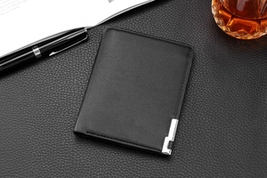 Business style black leather wallet with silver metal bar detail on a workspace desk