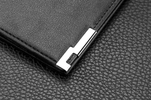 Macro shot of business wallet with textured black leather and silver metal corner detail