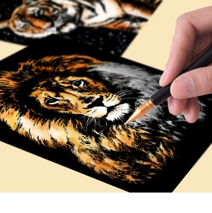 Détail de grattage d'un motif de lion doré sur papier d'art noir avec un stylet en métal