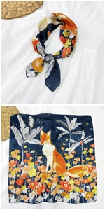 Dettaglio del foulard in seta blu navy con volpi arancioni e motivi floreali colorati
