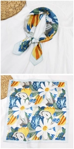 Dettaglio di un foulard quadrato in seta con vivaci motivi floreali e trama satinata