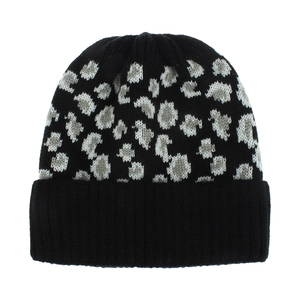 Détail de la texture en maille épaisse et du motif léopard gris sur le bonnet d'hiver noir