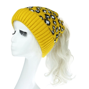 Détail du bonnet en maille pour queue de cheval avec motif léopard et texture côtelée jaune