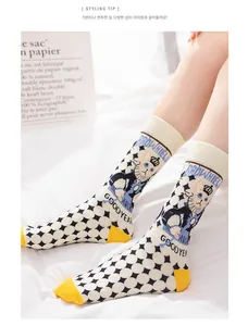 Detail of cotton crew socks featuring black white argyle patterns and cat illustrations