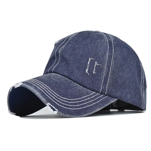 Detailansicht der dunkelblauen gewaschenen Denim-Basecap mit Distressed-Löchern und weißen Nähten