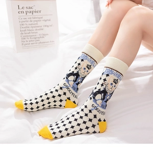 Detail of cotton crew socks with diamond pattern, cartoon dog art, and yellow toe design