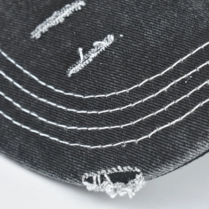 Detailansicht der Baseballkappe aus Denim mit Distressed-Effekt, Fransenlöchern und Nähten