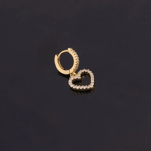 Détail de boucles d'oreilles cœur doré avec cristaux pavés et design évidé