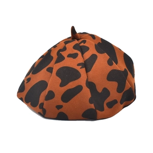 Close-up of brown cow print wool beret hat featuring vintage retro patterns and soft texture