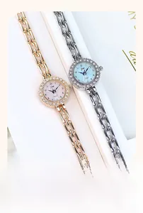 Detail of elegant quartz watches with diamond-encrusted bezels and slim metal chain straps